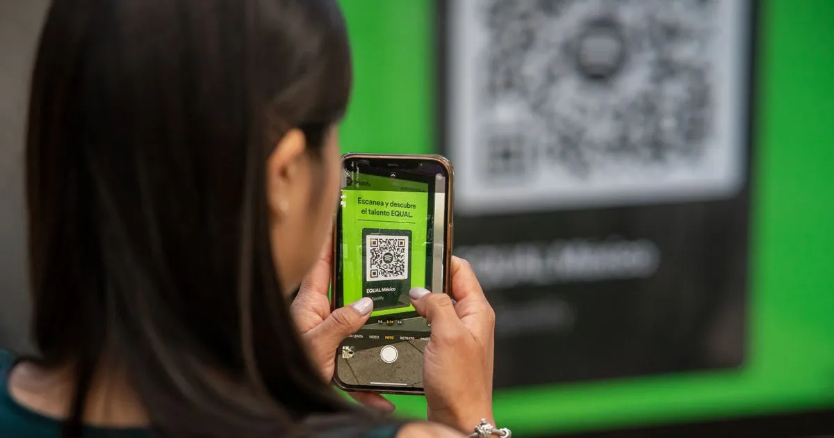 Persoană scanând un cod QR cu telefonul