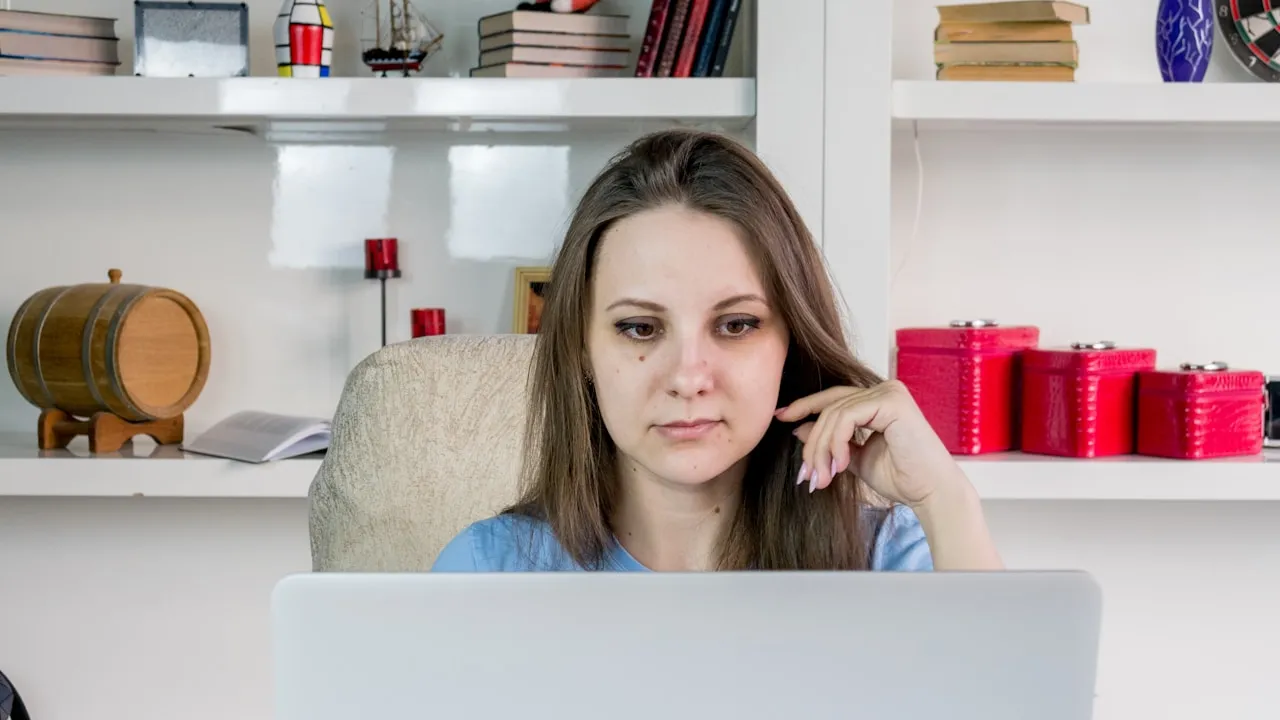 Femeie concentrată la laptop, lucrând la recuperarea unui cont