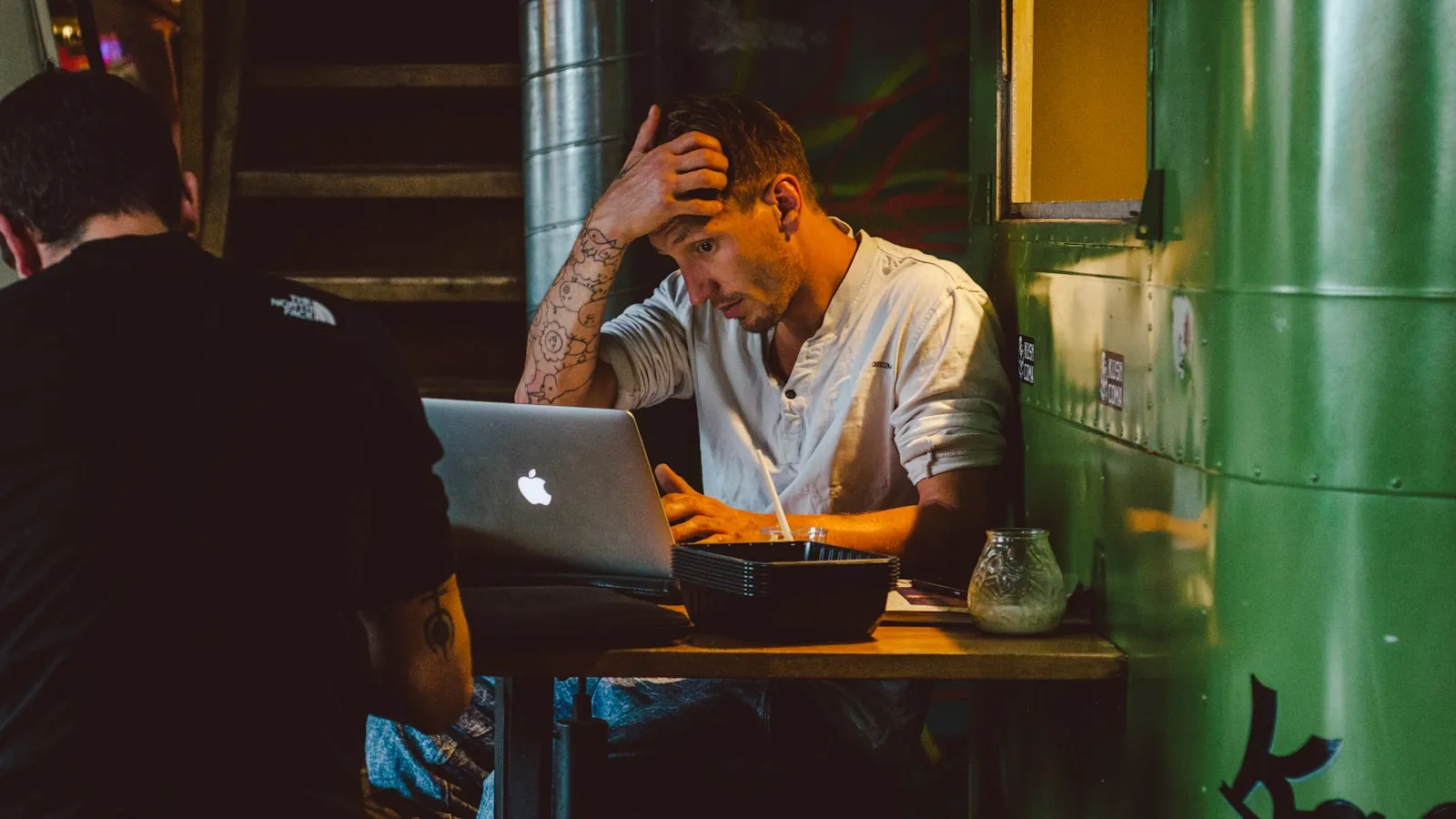 Bărbat concentrat la un laptop, încercând să își recupereze contul