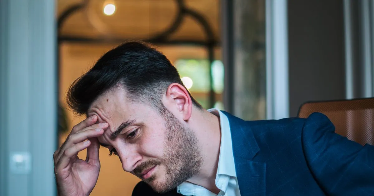 Proprietar de firmă mică la birou, privind îngrijorat ecranul laptopului