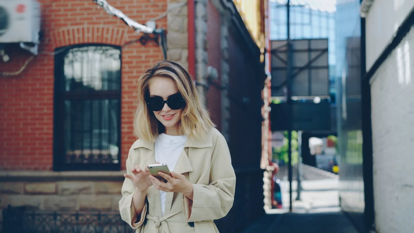 Tânără pe stradă folosind un telefon, într-un context obișnuit de social media