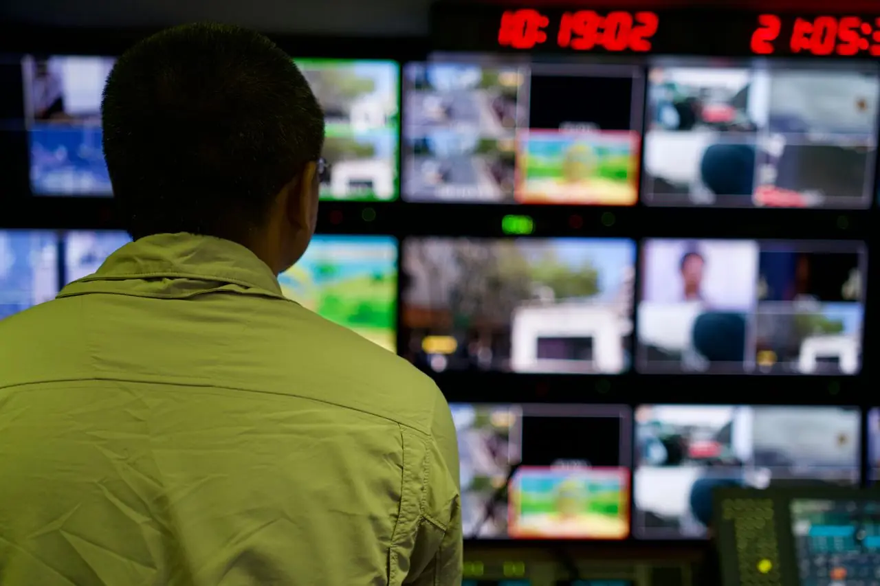 Operator urmărind mai multe monitoare într-un centru de operațiuni