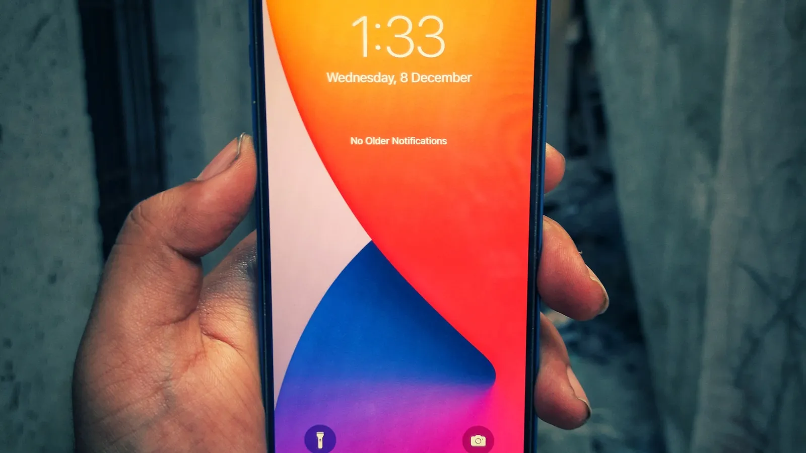 Mână ținând un telefon cu ecranul de blocare, gata de deblocare
