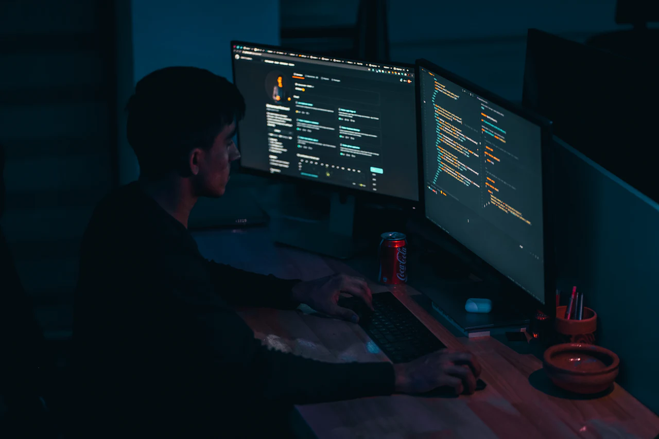 Specialist în securitate analizând rapoarte de vulnerabilități pe două monitoare