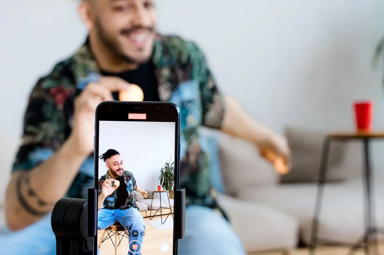 Creator de conținut filmând un clip cu telefonul pe trepied