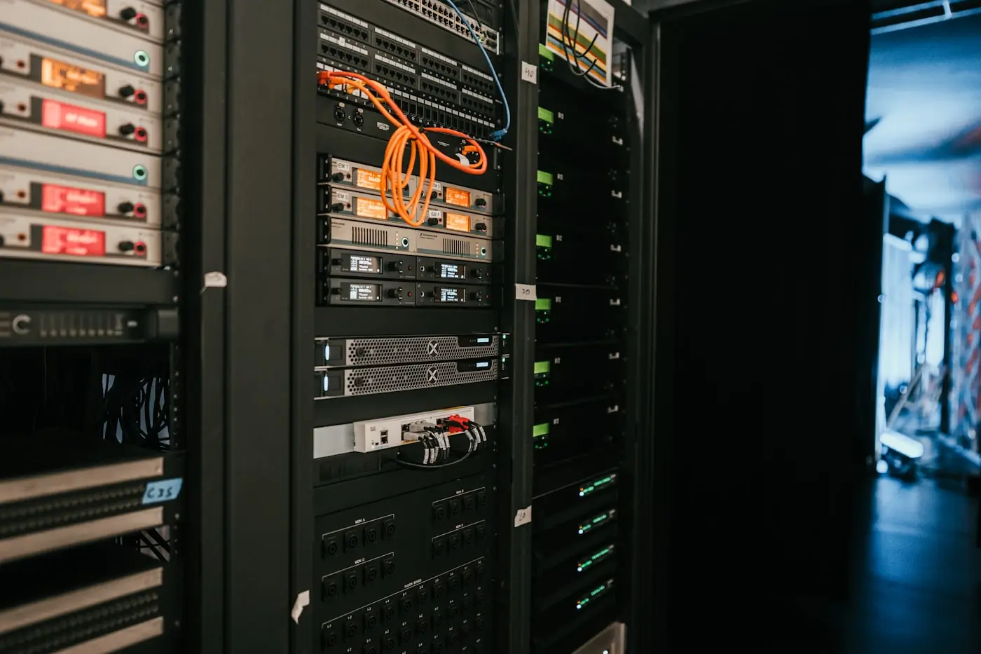 Rack de servere cu cabluri colorate și module într-o cameră de echipamente